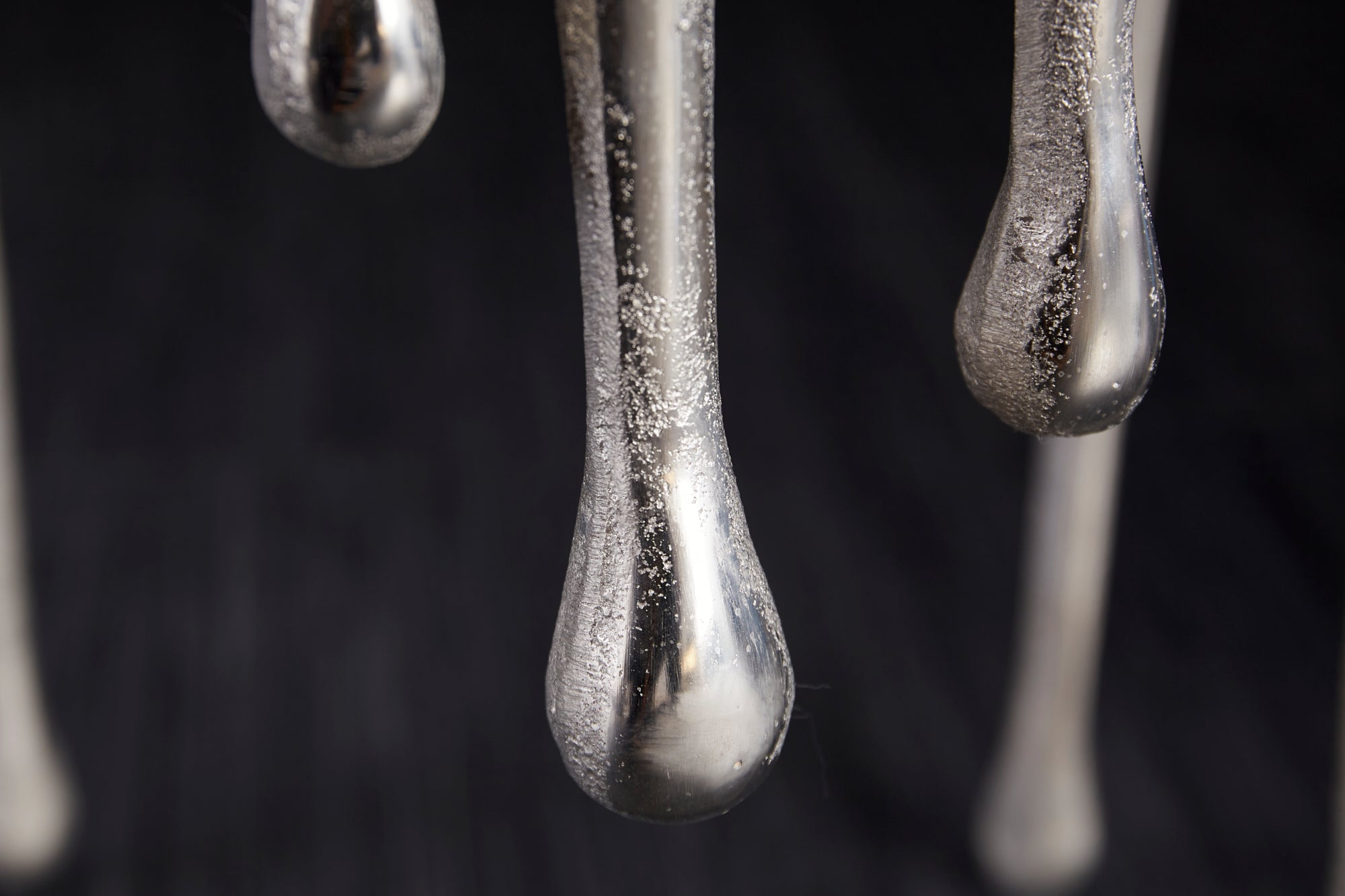 Extravagante mesa auxiliar redonda LIQUID LINE de 50 cm con diseño de gota metálica de aluminio