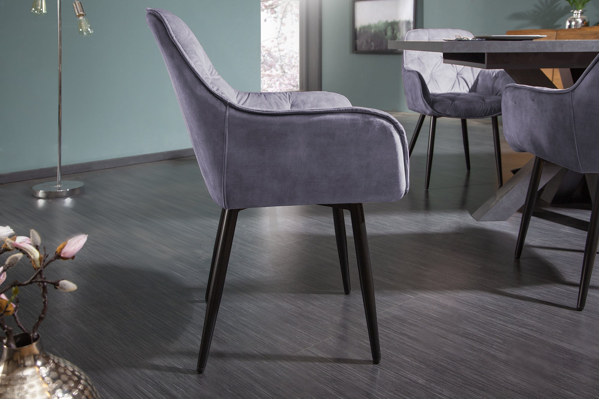 Chaise design MILANO en velours gris avec accoudoirs matelassés décoratifs et pieds en métal noir rembourrés